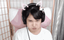a girl wearing headphones with cat ears on her head looks angry