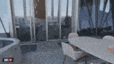 a sliding glass door is open to a room with a table and chairs and the words as tv on the bottom right