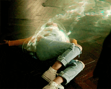 a person laying on the floor with their legs crossed and their converse shoes on