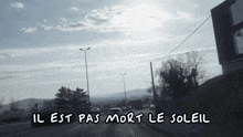 a black and white photo of a street with the words il est pas mort le soleil above it