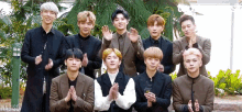 a group of young men are standing next to each other and clapping their hands .