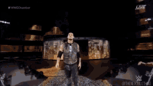 a man in a vest is walking on a stage with a sign that says live on it