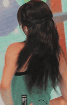 a woman with long dark hair is wearing a braided ponytail