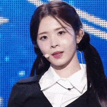 a woman with pigtails is wearing a white shirt and a microphone