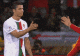 a soccer player wearing a white shirt with a green and red stripe