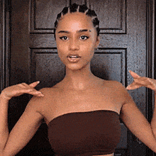 a woman in a strapless top is standing in front of a door .