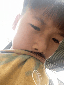 a close up of a person 's face with a yellow shirt that has the letter p on it