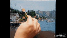 a hand is holding a brush in front of a painting with the words made in animatica on the bottom