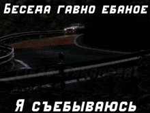 a white car is driving down a road at night with russian writing