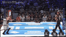 a wrestling match is being played in front of a crowd and a referee