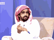 a man wearing a head scarf is sitting in a chair with channels written on the bottom