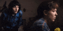 a man in a blue plaid shirt is sitting next to a woman