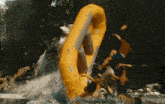a group of people are in a yellow raft in a waterfall
