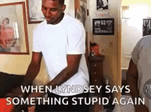 a man in a white shirt is standing in a room and says when lyndsey says something stupid again