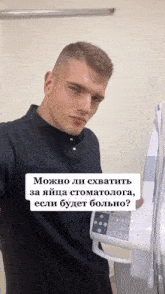 a man in a black shirt is holding a machine with the words " можно ли схватить за яйца стоматолога "
