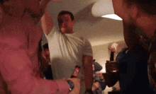 a man in a pink shirt is holding a bottle with a red label that says ' coca cola ' on it