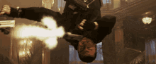 a man is hanging upside down with a gun in his hand