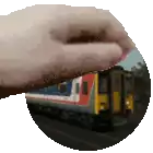 a hand is holding a picture of a train in the background