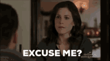 a woman is talking to a man and says `` excuse me ? ''