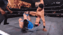 two men are wrestling in a ring with a cw logo on the wall