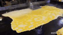 a large piece of omelet is being cooked on a grill with the words made in animotica visible in the corner