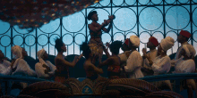 a group of people dancing in front of a fence with the letter z on the top