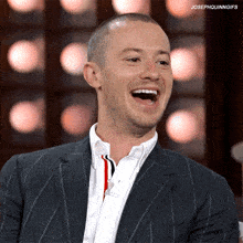 a man in a suit and white shirt is laughing with the caption josephquinngifs above him