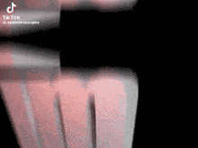 a close up of a person 's hand on a black background with a blurred image .