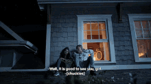 a man and a woman are sitting on the roof of a house at night