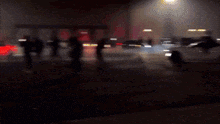 a car is driving down a street at night with smoke coming out of it
