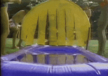 a group of people are playing in a pool with an inflatable chair in the middle