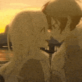 a boy and a girl are kissing each other in front of a sunset .