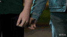 a person holding another person 's hand with a netflix logo in the background