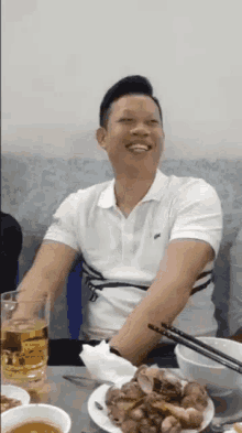 a man sitting at a table with plates of food and a glass of beer .