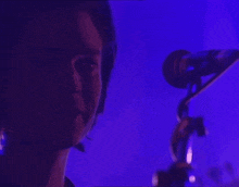 a close up of a person 's face with a purple background