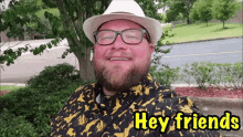 a man wearing a hat and glasses is smiling and says hey friends