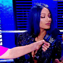 a woman is holding a microphone with a w logo on it