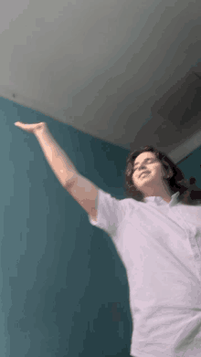 a person in a white shirt is standing with their arm outstretched