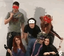 a group of people are posing for a picture wearing masks