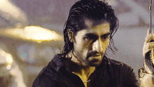 a man with long hair and a beard holding an umbrella in the rain