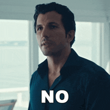 a man in a blue shirt says " no " in white letters
