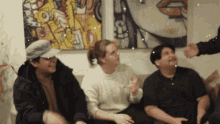a group of people are sitting in front of a painting that says " love " on it