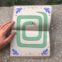 a person is holding a book open to a page with a green snake on it