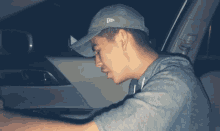 a man wearing a new era hat is sitting in the back seat of a car