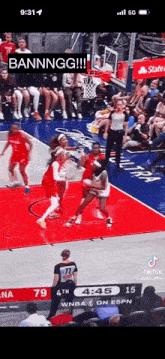 a basketball game is being played in front of a crowd of people .