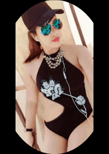 a woman in a black swimsuit and sunglasses is wearing a hat
