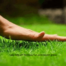 a person 's foot is laying on a lush green lawn .
