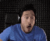 a man wearing headphones is sitting in a chair with his mouth open .