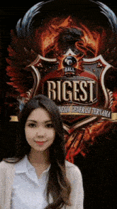 a woman stands in front of a shield that says biggest