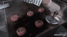 a hamburger patty is being cooked on a grill with the words made in animotica below it
